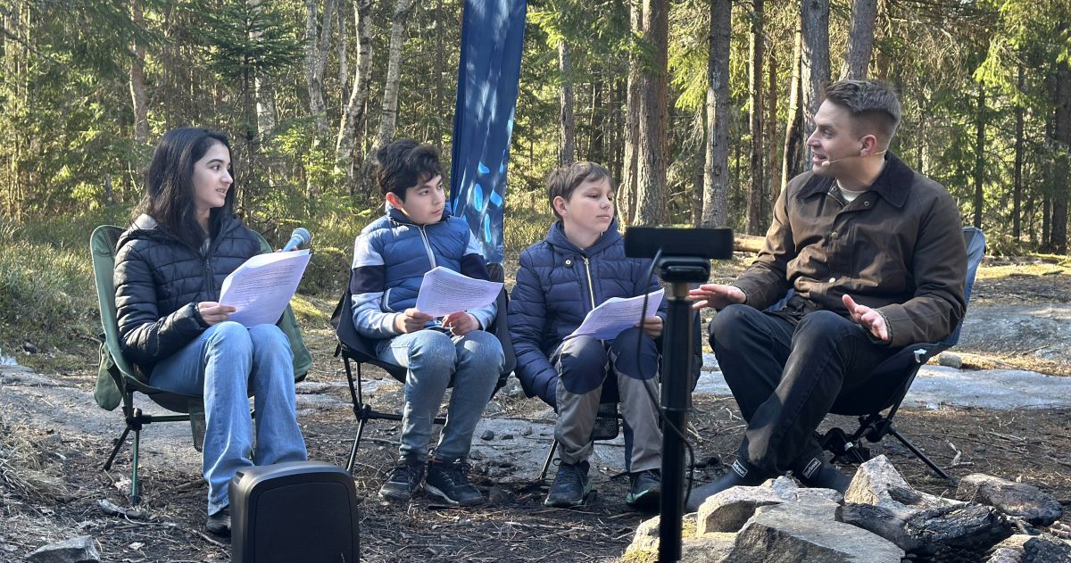 Tre elever som intervjuer forfatter Håkon Marcus ute i skogen