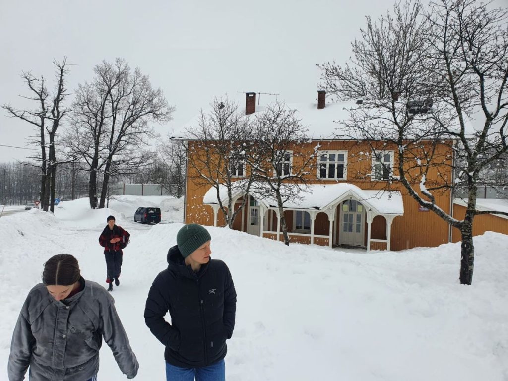 Utøverne i Økohelter utenfor en skole om vinteren