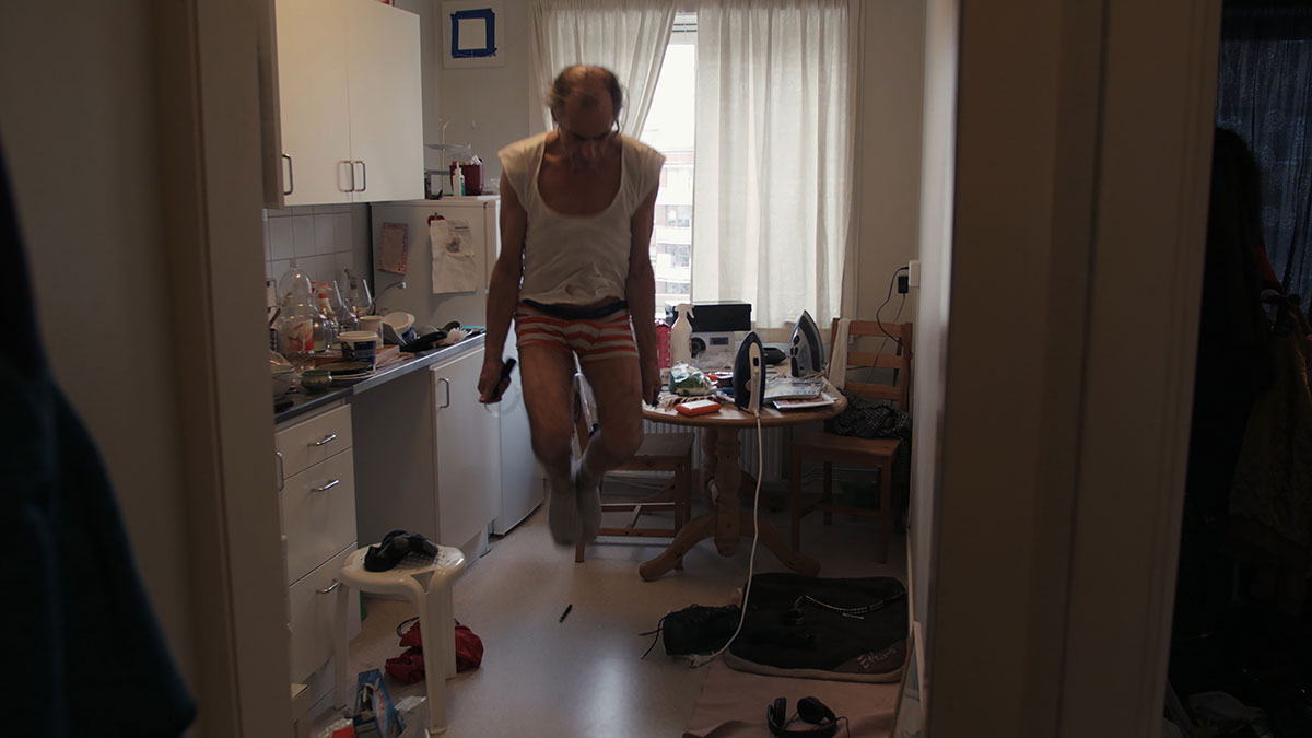 Stillbilde fra filmen "Røverdatter". Faren til regissør Sofia Haugan hopper inne på et kjøkken.