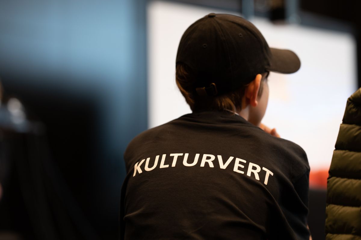Bilde bakfra av elev med kulturvert t-skjorte og caps