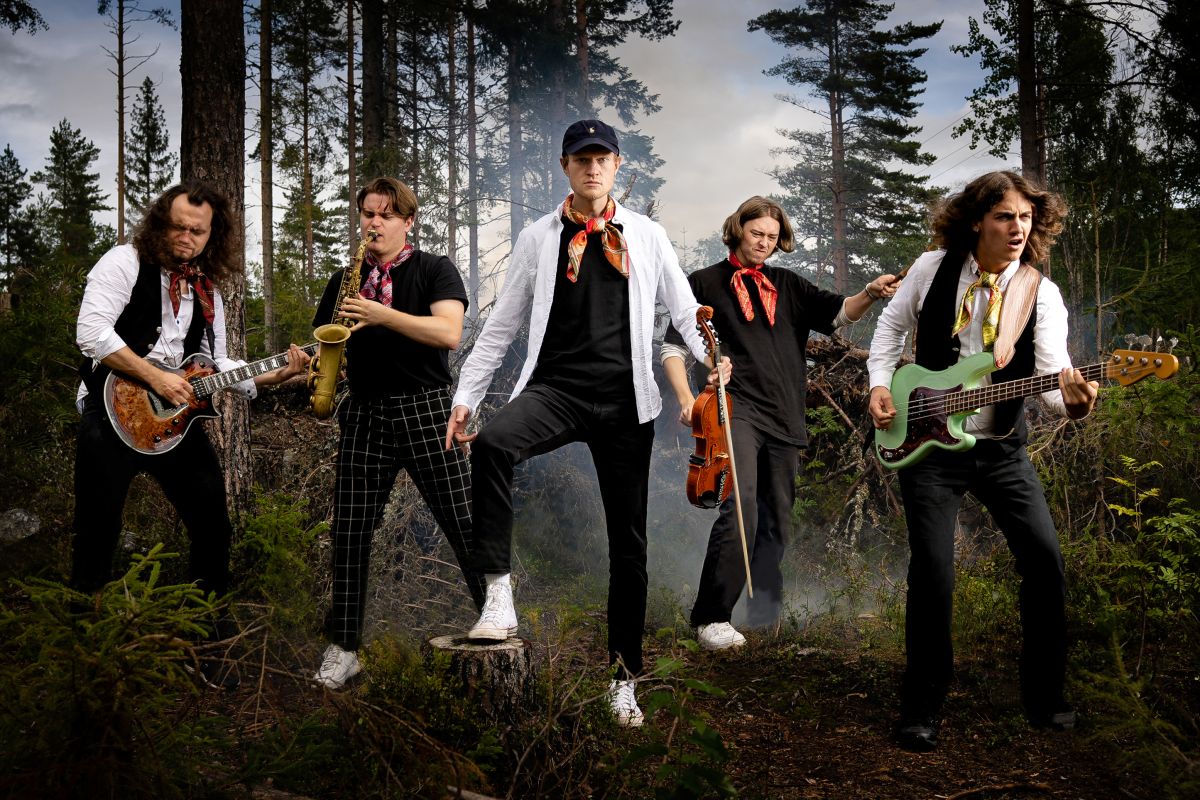 Bilde av de fem medlemmene i bandet GANGAR ute i skogen med instrumentene sine mens de poserer for fotoggrafen.